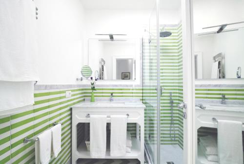 a bathroom with two sinks and green and white stripes at Villa Massa Residence in Sant'Agnello