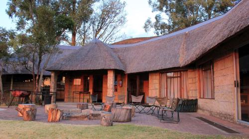 a log cabin with a table and chairs in front of it at Sungubala Eco Camp in Bergville