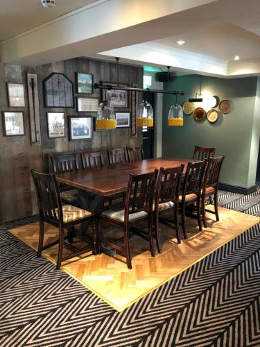 a dining room with a wooden table and chairs at Green Lodge, Wirral by Marston's Inns in Hoylake