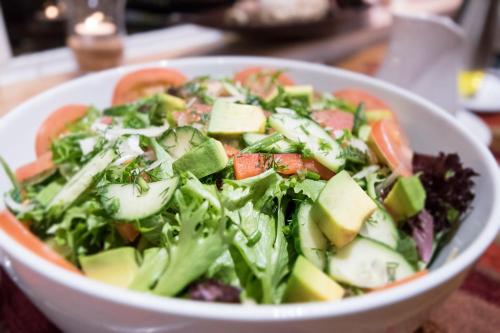 a salad in a white bowl on a table at Dornhuegel Guest Farm in Groutfontein