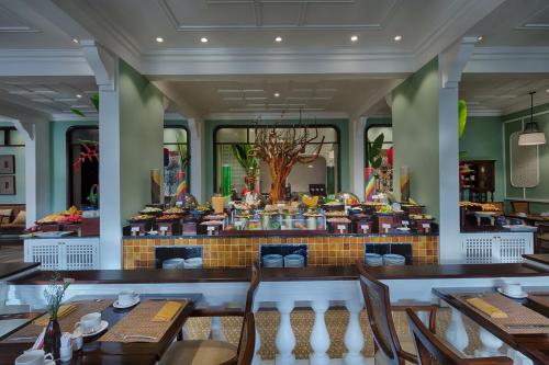 a restaurant with tables and chairs and a buffet at Allegro Hoi An . A Little Luxury Hotel & Spa in Hoi An