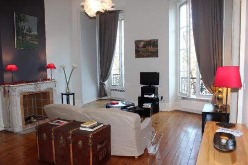 sala de estar con sofá y chimenea en Burdigala Homes - Appart Clemenceau, en Burdeos