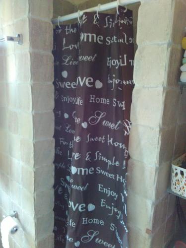eine Wand mit Schrift darauf in einem Badezimmer in der Unterkunft Sole Mio in Milína