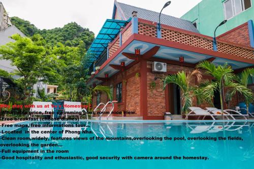 a building with a swimming pool in front of it at Vu's Homestay in Phong Nha