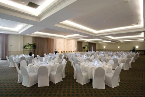 a banquet hall with white tables and white chairs at Distinction Palmerston North Hotel & Conference Centre in Palmerston North