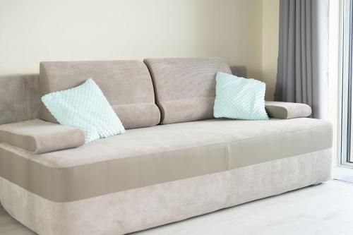 a couch in a living room with two pillows on it at Apartment Flamingo 27 by Renters in Międzyzdroje
