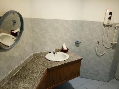 a bathroom with a sink and a shower with a mirror at Pruksa Garden Hotel in Phu Wiang