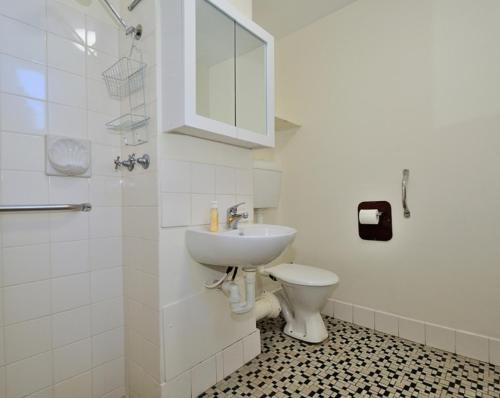 a white bathroom with a sink and a toilet at Cappuccino Delight - 1 bedroom central Fremantle apartment in Fremantle