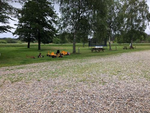 a group of picnic tables in a park at Rejkjær Camping Hytter & Lejligheder in Ulfborg