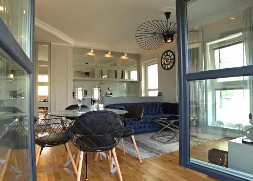 a dining room and living room with a table and chairs at Blue Velvet Premium Apartments II in Toruń