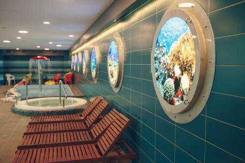 a bathroom with two benches and a sink and mirrors at Daina Jurmala Beach Hotel in Jūrmala