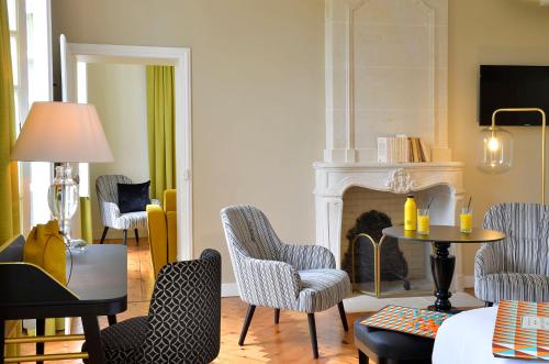 a living room with chairs and a fireplace at Château Saint Gilles - Bayeux in Guéron