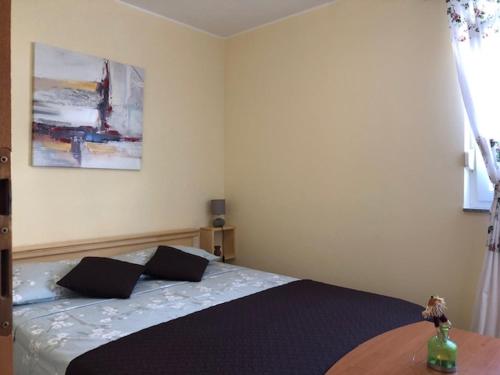 a bedroom with a bed with two pillows on it at Apartman Sena in Vodice