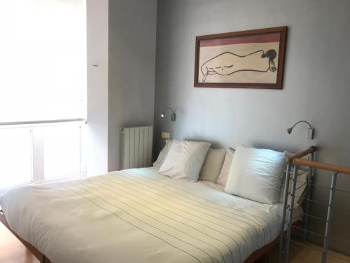 a bed with white sheets and a picture on the wall at Old Town & River (Casco Viejo Bilbao) E-BI 1138 in Bilbao