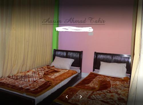 two beds sitting next to each other in a room at Flora Inn Hotel Naran in Nārān