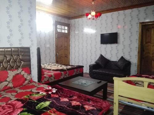 - un salon avec un lit et un canapé dans l'établissement Greenland Motel, à Mānsehra