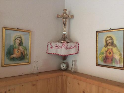 ein Kreuz auf einem Regal mit zwei Bildern in der Unterkunft Wöscherhof in Kaltenbach