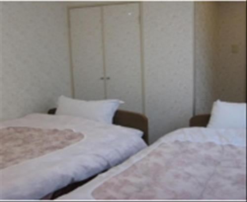 two beds sitting next to each other in a room at Takaraya in Kotohira