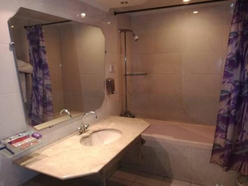 a bathroom with a sink and a tub with a mirror at Hotel City View Peshawar in Peshawar