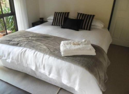 a bed with two white towels on top of it at Waters Edge B&B in Kaitaia