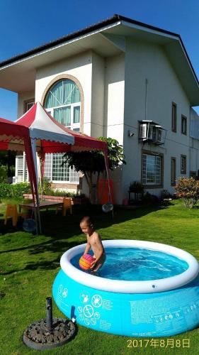 a young boy in a pool in a yard at Emerald Grange in Gongguan