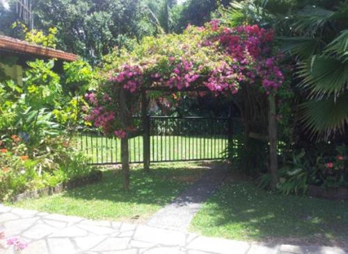a black fence with pink flowers on it at Waters Edge B&B in Kaitaia