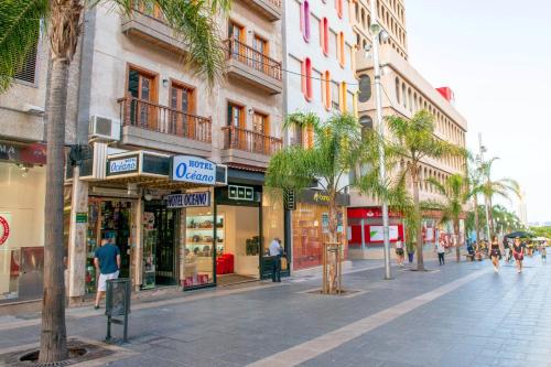 una calle de la ciudad con tiendas y palmeras en una ciudad en Hotel Océano Centro en Santa Cruz de Tenerife