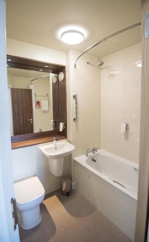 a bathroom with a sink and a toilet and a bath tub at Queen of the Loch, Balloch by Marston's Inns in Balloch