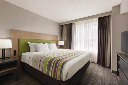 a hotel room with a bed and a television at Country Inn & Suites by Radisson, Beaufort West, SC in Beaufort