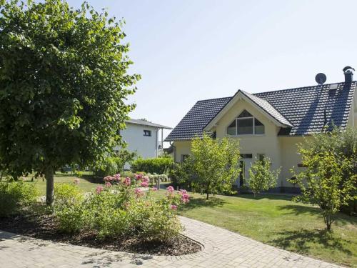 オストゼーバート・ゼリンにあるFerienwohnung am Waldesrandの花と木の庭園のある家