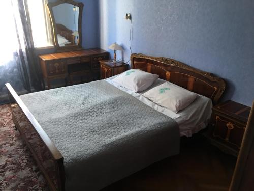 Dormitorio con cama con espejo y tocador en Hause en Tskaltubo