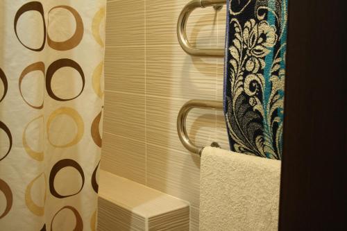 a bathroom with a shower curtain and a towel at 1-комнатная квартира на набережной in Pavlodar