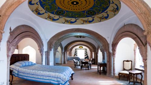 a bedroom with an ornate ceiling and a bed at Neemrana's - Tijara Fort Palace in Alwar