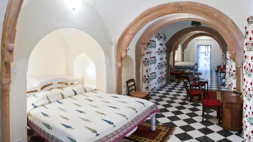 a bedroom with a bed and a checkered floor at Neemrana's - Tijara Fort Palace in Alwar