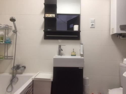 a white bathroom with a sink and a shower at Wyjątkowy apartament w sercu Piły in Piła