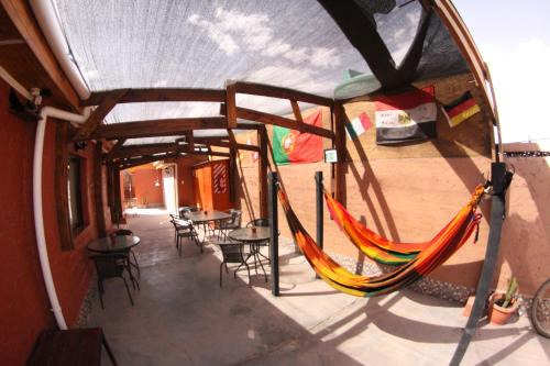 a patio area with chairs, tables and umbrellas at Hostal Campo Base in San Pedro de Atacama