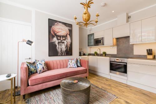 a living room with a pink couch in a kitchen at L-Spa Boutique Apartments in Leamington Spa