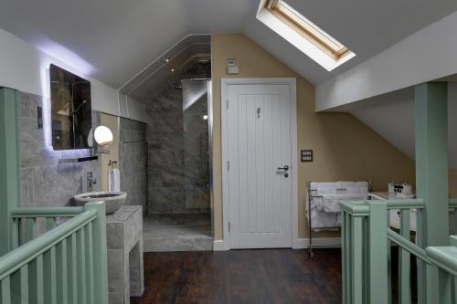 a bathroom with a walk in shower and a sink at Rogerthorpe Manor Hotel in Pontefract