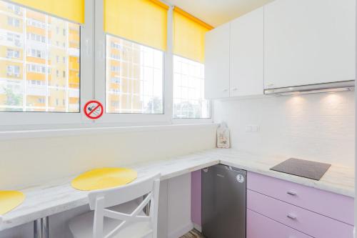 a kitchen with a counter with a table and two stools at Квартира подобово на Юлії ЗдановськоЇ, ВДНГ in Kyiv