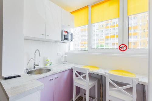 a kitchen with a sink and two chairs in it at Квартира подобово на Юлії ЗдановськоЇ, ВДНГ in Kyiv