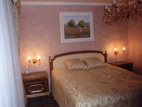 ein Schlafzimmer mit einem Bett mit zwei Nachttischen und zwei Leuchten in der Unterkunft VILLAS and SUITES LA CORAILLERE RESORT in Théoule-sur-Mer