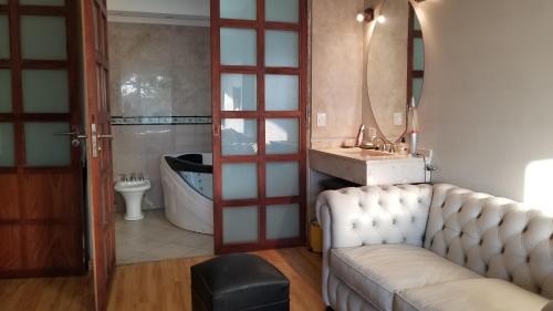 a bathroom with a couch and a sink and a tub at RENTAL FLAT BOUTIQUE PILAR in Pilar