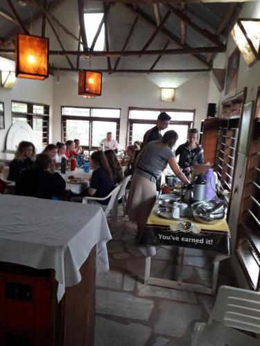 a group of people in a restaurant preparing food at Masaka Backpackers, Tourists Cottage & Campsite in Masaka