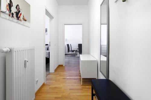 an apartment with white walls and a hallway with a mirror at Grand Central Mitte Apartment in Berlin