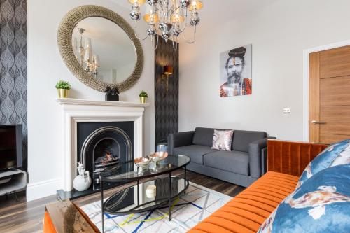 レミントン・スパにあるL-Spa Boutique Apartmentsのソファと鏡のあるリビングルーム
