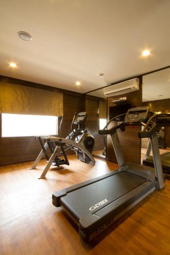 a gym with two exercise bikes and a treadmill at Leisure Inn Grand Chanakya in Jaipur