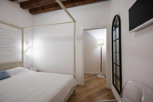 a white bedroom with a bed and a mirror at Privacy in Venice - Your apartment to be let alone in Venice