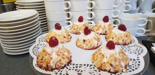 a plate of muffins with strawberries on top of them at Eurohotel Swarzędz in Swarzędz