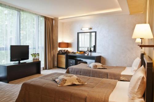 une chambre d'hôtel avec deux lits et une télévision dans l'établissement Efbet Hotel, à Varna