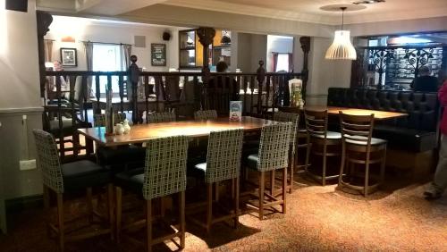 a restaurant with a wooden table and chairs at Woodcocks, Lincoln by Marston's Inns in Lincoln